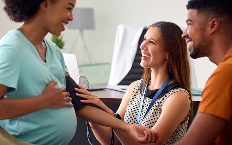 Pregnant woman getting blood pressure checked with husband