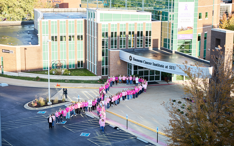 Simmons Cancer Institute pink ribbon of people in parking lot