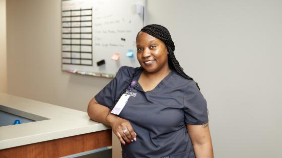Medical assistant stands at nurses station