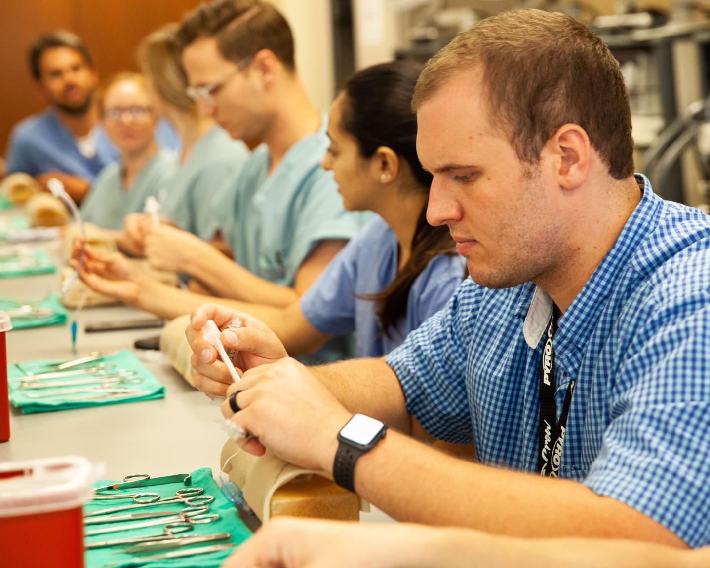 Students sitting at a table with surgical tools