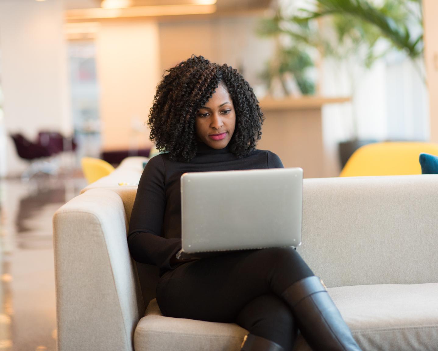 Woman on laptop seated comfortably on the couch
