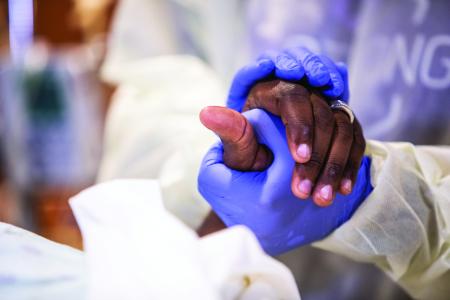 Patient holds doctor's hand