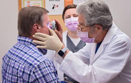 Dermatologist checks on a mole near a patients eye