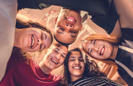 Group of people standing together in a circle 