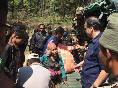 Dr. Koirala (on right in blue) works with the ANMF and Nepal military to take supplies, food and shelter to the people of Nepal.