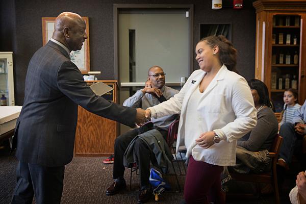 Dr. Wesley McNeese presents Dayshia Rogers-Gordon with a handshake and her graduation certificate at the P4 graduation ceremony in the Pearson Museum on March 30.